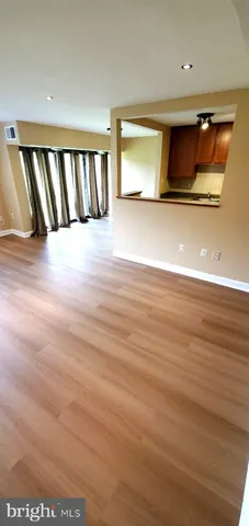 a view of a room with wooden floor and window