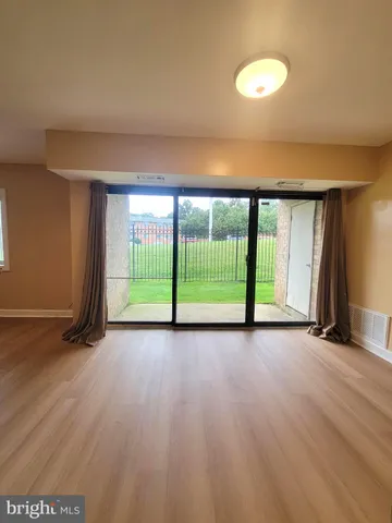 a view of a room with wooden floor and a window