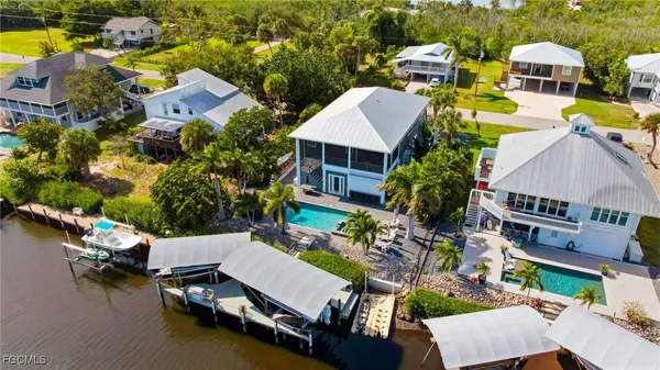 an aerial view of a house with swimming pool and ocean view