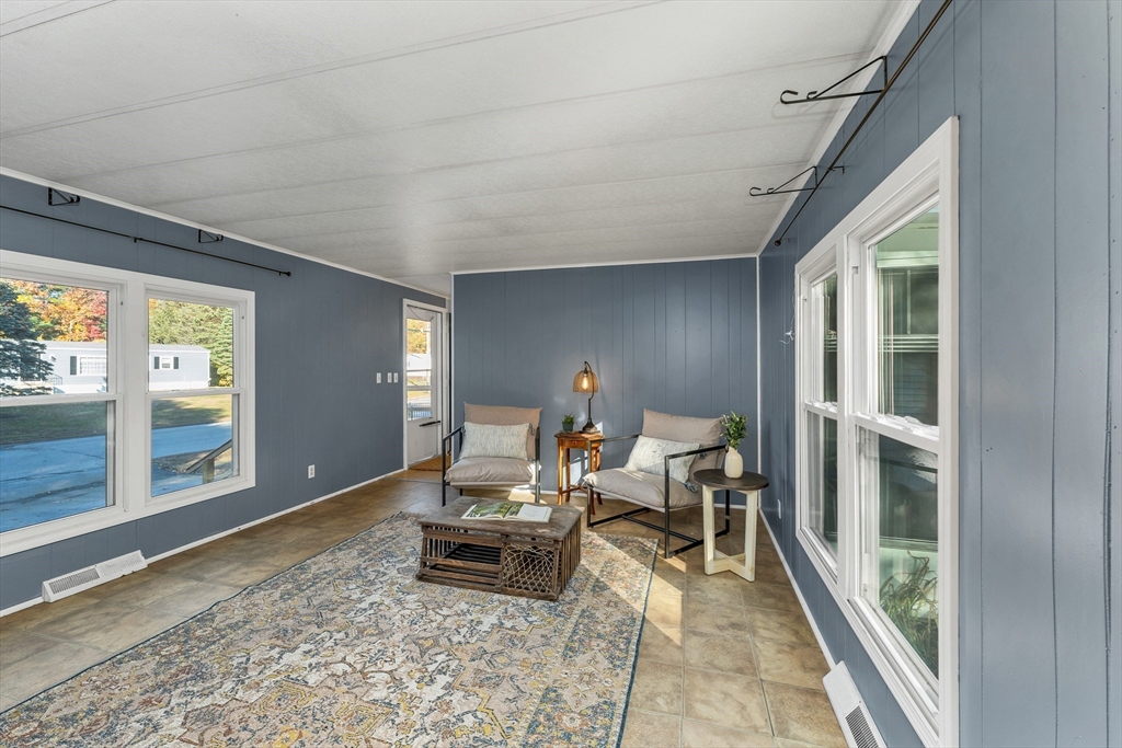 28 Brooks Road, Unit 28 Seabrook, NH 03874 - Photo 11 of 34 a living room with furniture a rug and a large window