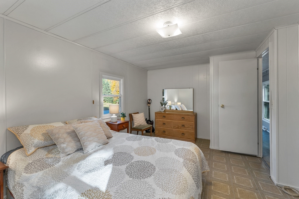 28 Brooks Road, Unit 28 Seabrook, NH 03874 - Photo 14 of 34 a bedroom with a bed and wooden floor