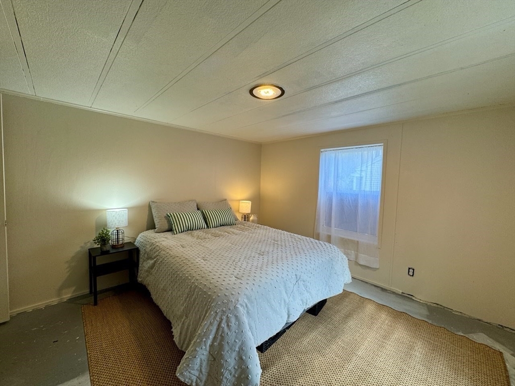 28 Brooks Road, Unit 28 Seabrook, NH 03874 - Photo 21 of 34 a bedroom with a bed and a lamp