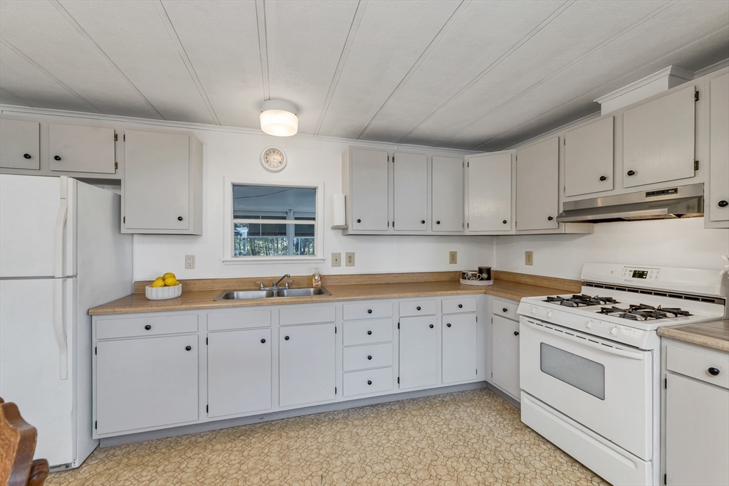28 Brooks Road, Unit 28 Seabrook, NH 03874 - Photo 5 of 34 a kitchen with granite countertop a sink a stove and cabinets