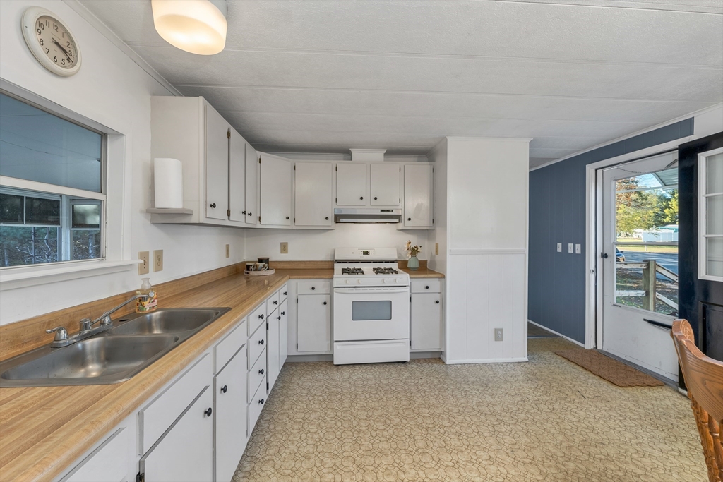 28 Brooks Road, Unit 28 Seabrook, NH 03874 - Photo 6 of 34 a kitchen with granite countertop a sink stove and cabinets