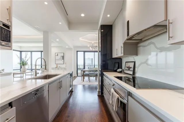 a kitchen with stainless steel appliances granite countertop a sink a stove and a wooden floors