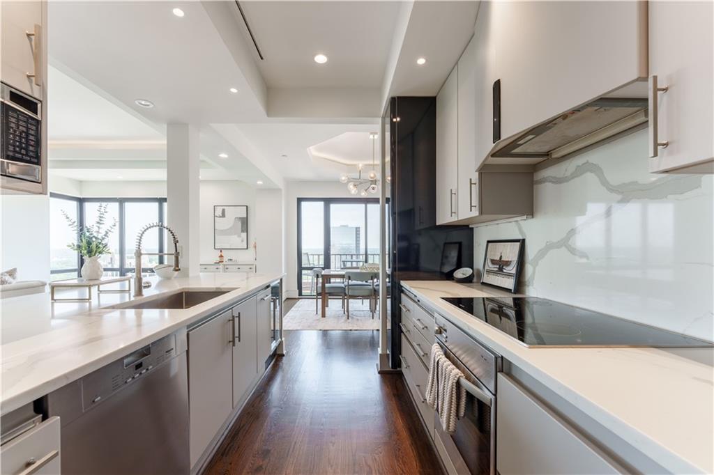 3475 Oak Valley Road Northeast, Unit 2940 Atlanta, GA 30326 - Photo 15 of 26 a kitchen with stainless steel appliances granite countertop a sink a stove and a wooden floors