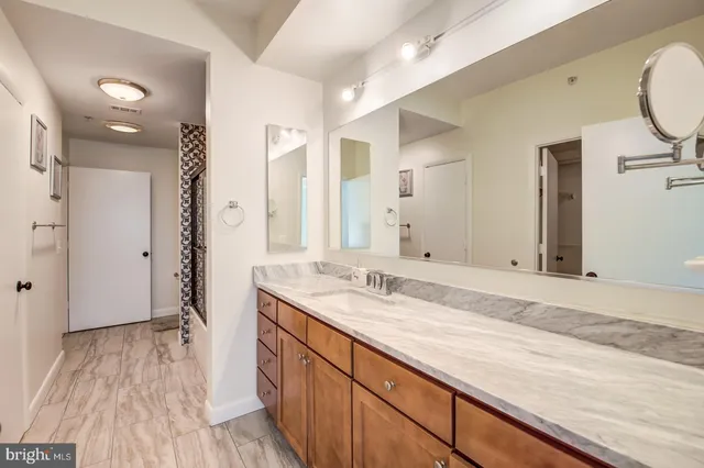 a bathroom with a granite countertop sink mirror and shower