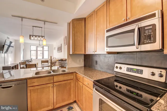 a kitchen with stainless steel appliances granite countertop a sink stove and microwave