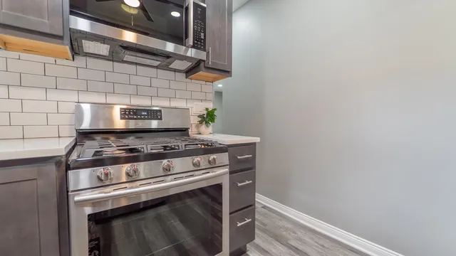 a stove top oven sitting inside of a kitchen