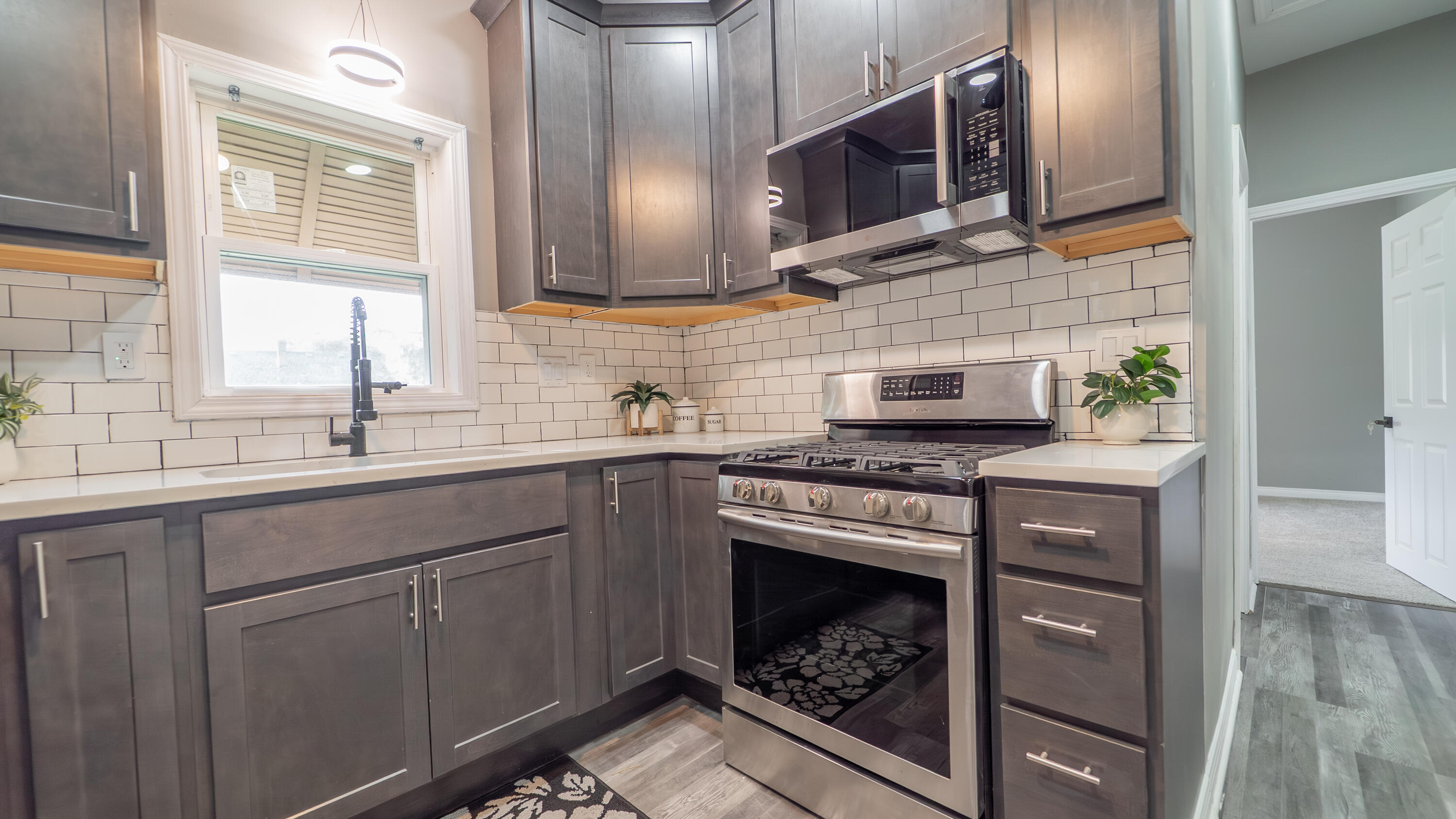 2257 West 16th Avenue Gary, IN 46404 - Photo 14 of 24 a kitchen with stainless steel appliances granite countertop a stove a sink and a microwave