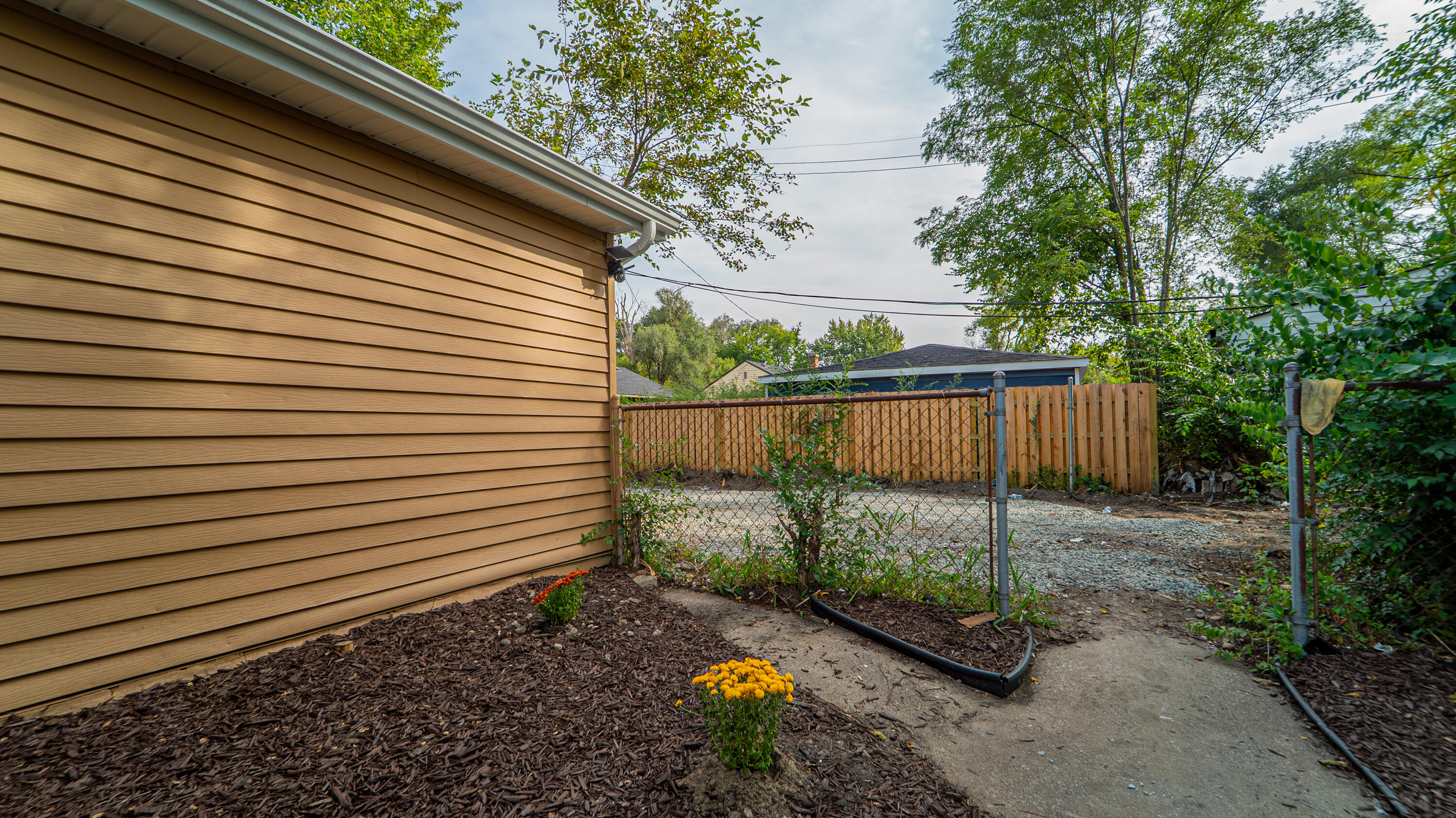 2257 West 16th Avenue Gary, IN 46404 - Photo 22 of 24 a view of a backyard with plants and wooden fence