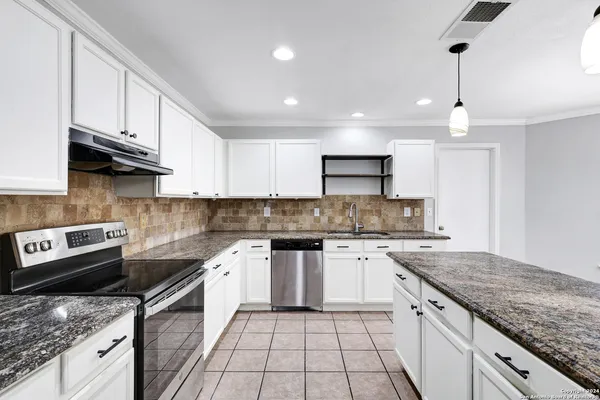 a kitchen with granite countertop cabinets stainless steel appliances and a counter space