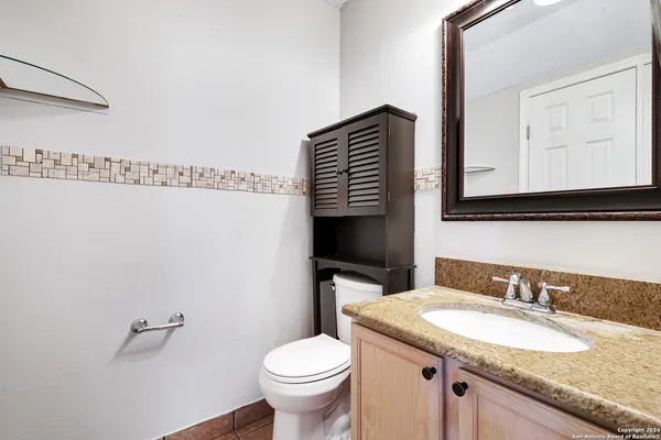 a bathroom with a granite countertop sink and a mirror