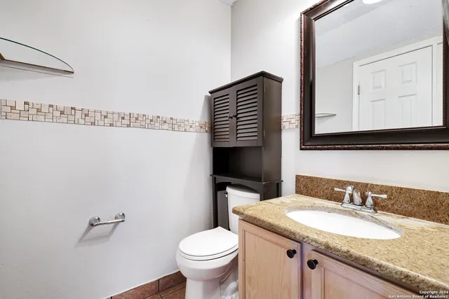a bathroom with a granite countertop sink and a mirror