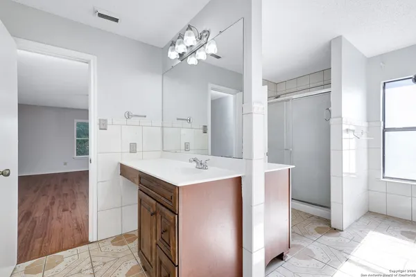 a bathroom with a sink a mirror and a shower