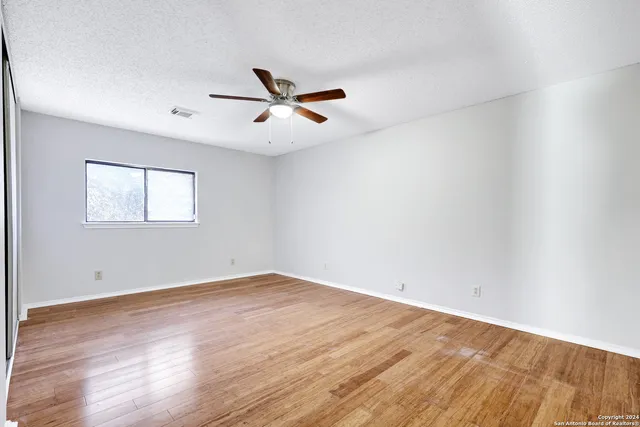 a view of empty room with wooden floor
