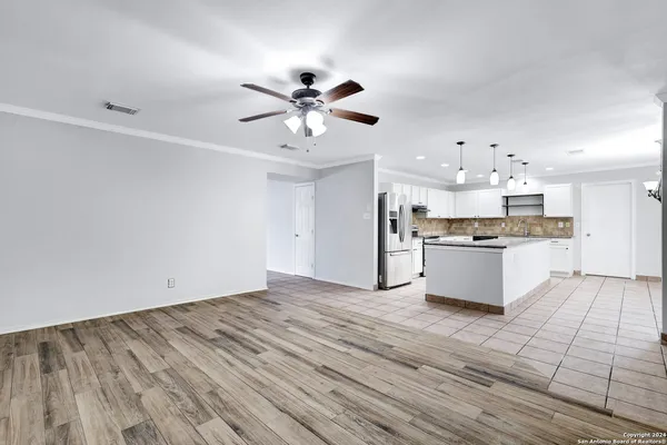 a view of kitchen with granite countertop cabinets and refrigerator