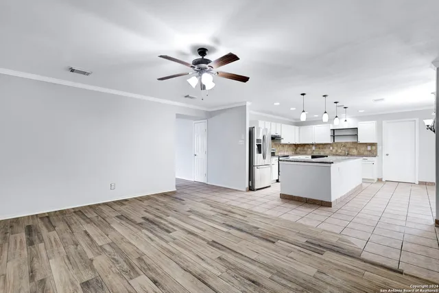 a view of kitchen with granite countertop cabinets and refrigerator