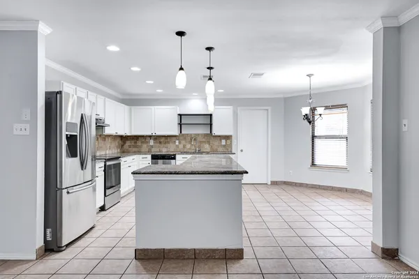 a kitchen with kitchen island a sink stainless steel appliances and window