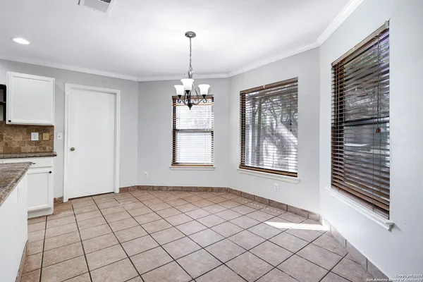 a view of an empty room with window and cabinet