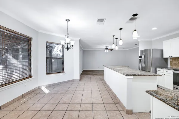 a kitchen with kitchen island granite countertop a stove a sink a refrigerator and a granite counter tops