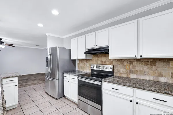 a kitchen with stainless steel appliances granite countertop a refrigerator sink and cabinets