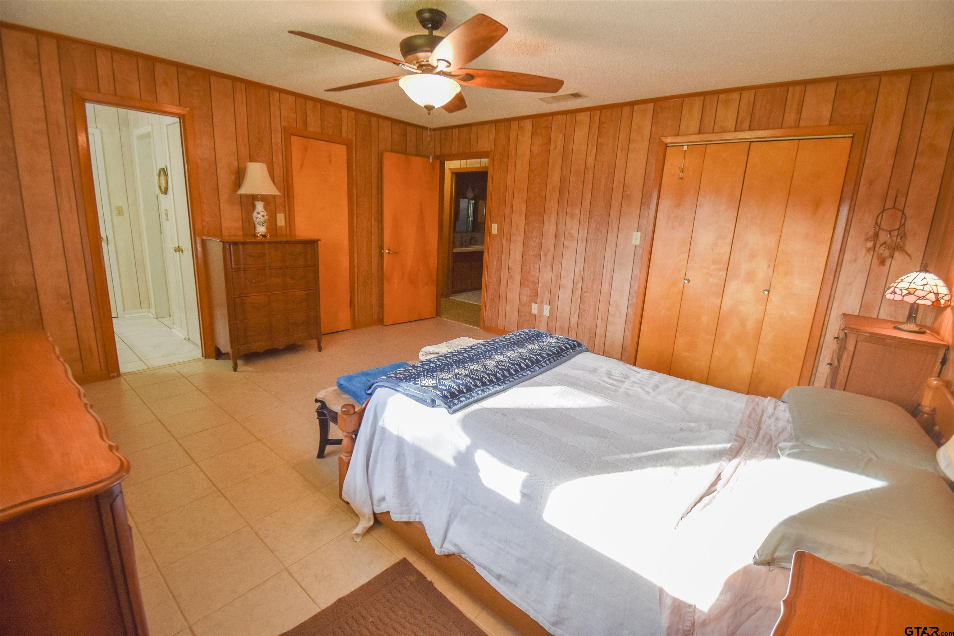 355 West Sugar Hill Road Reklaw, TX 75784 - Photo 17 of 38 a bedroom with a bed and a chandelier