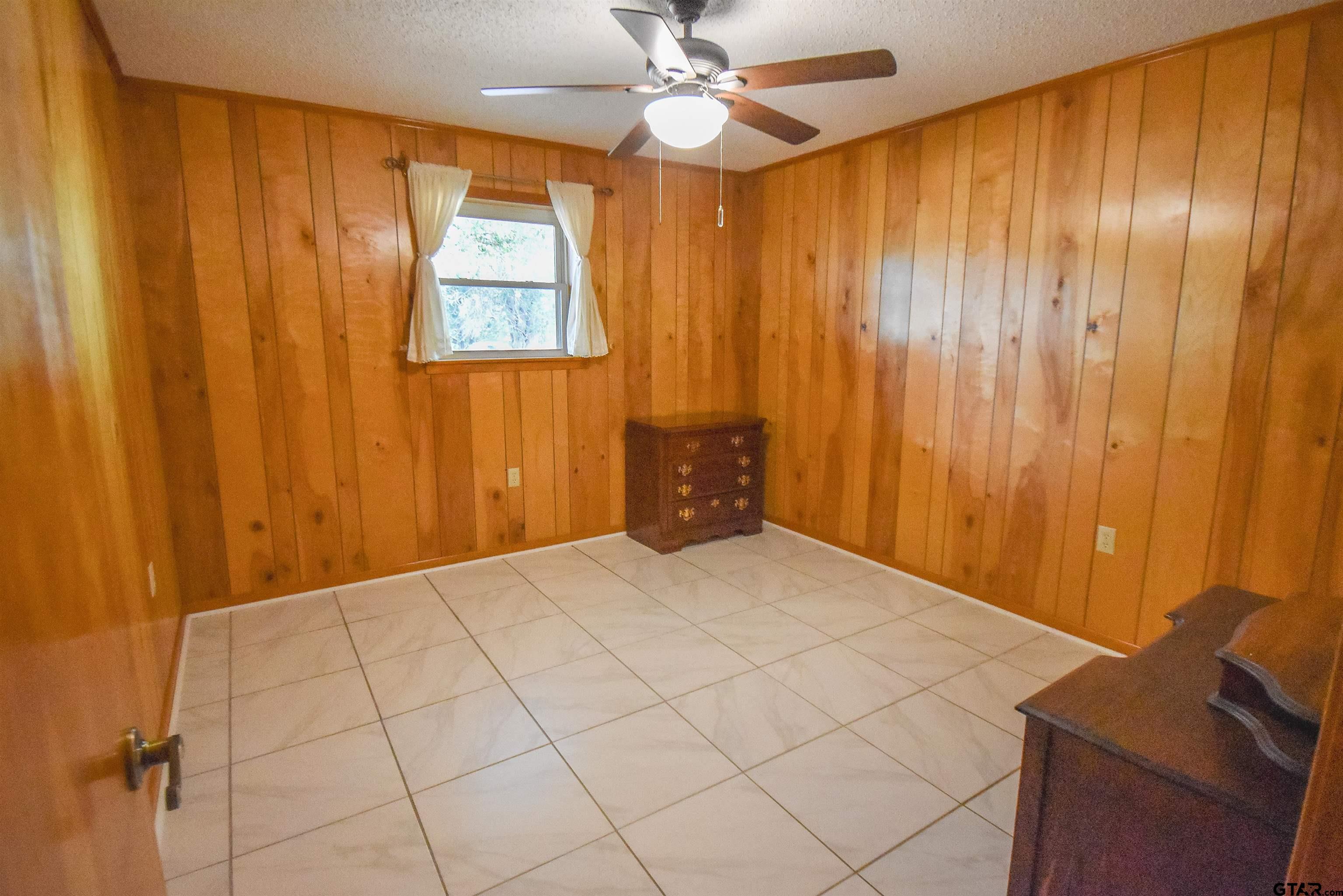 355 West Sugar Hill Road Reklaw, TX 75784 - Photo 25 of 38 a bedroom with a bed and a chandelier