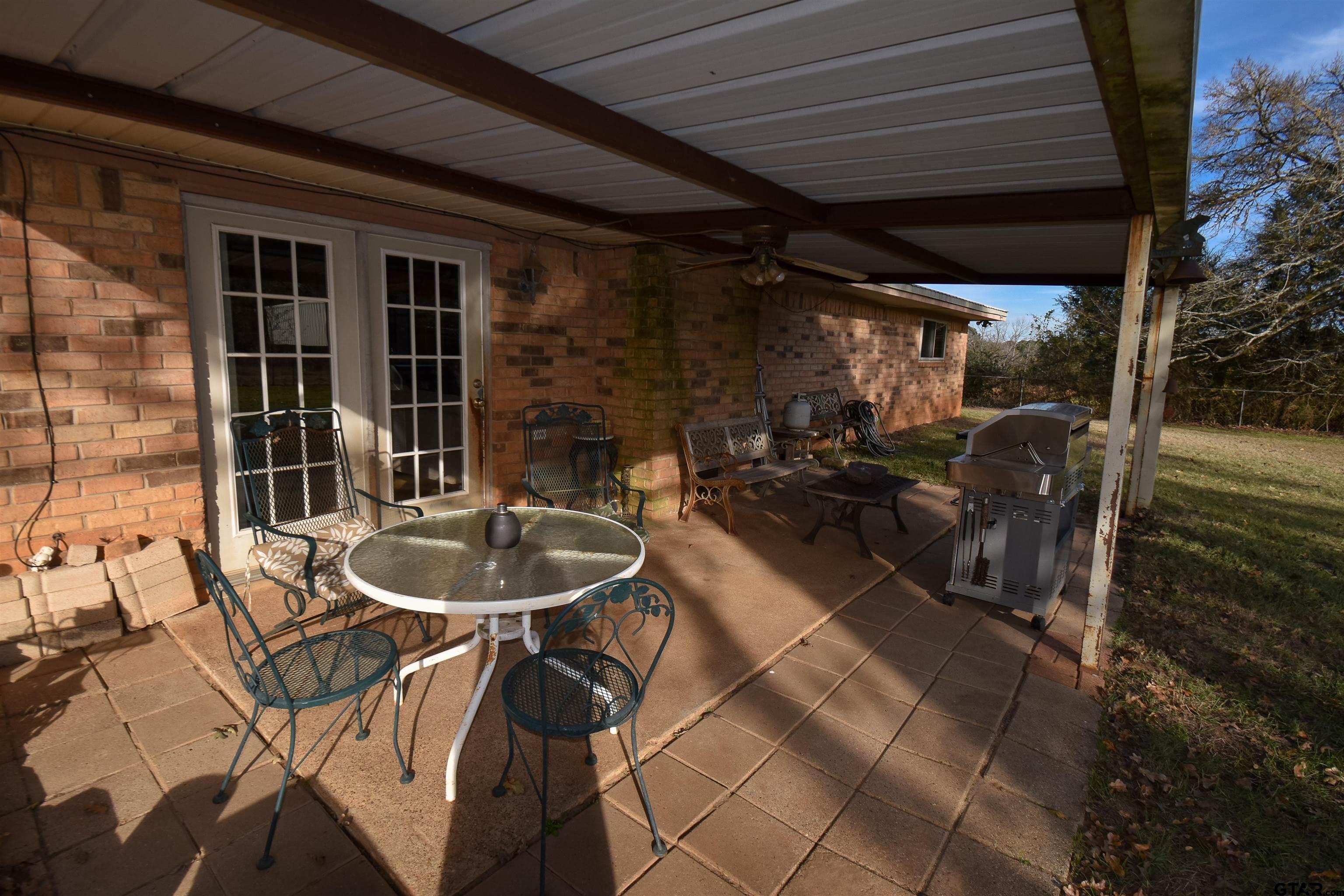 355 West Sugar Hill Road Reklaw, TX 75784 - Photo 33 of 38 a view of a patio with table and chairs with wooden floor and fence