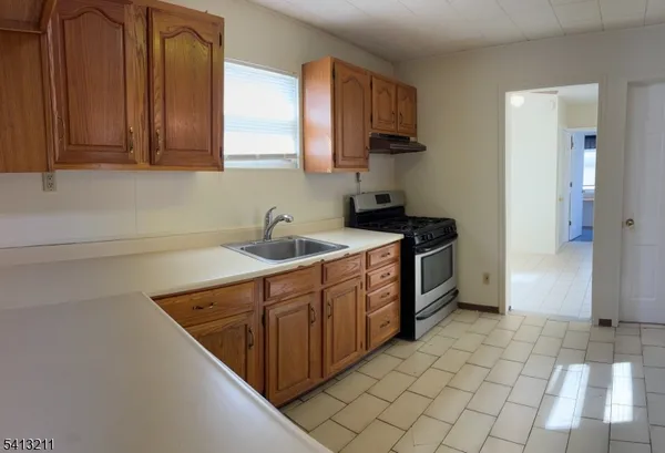 a kitchen with a sink a stove and cabinets