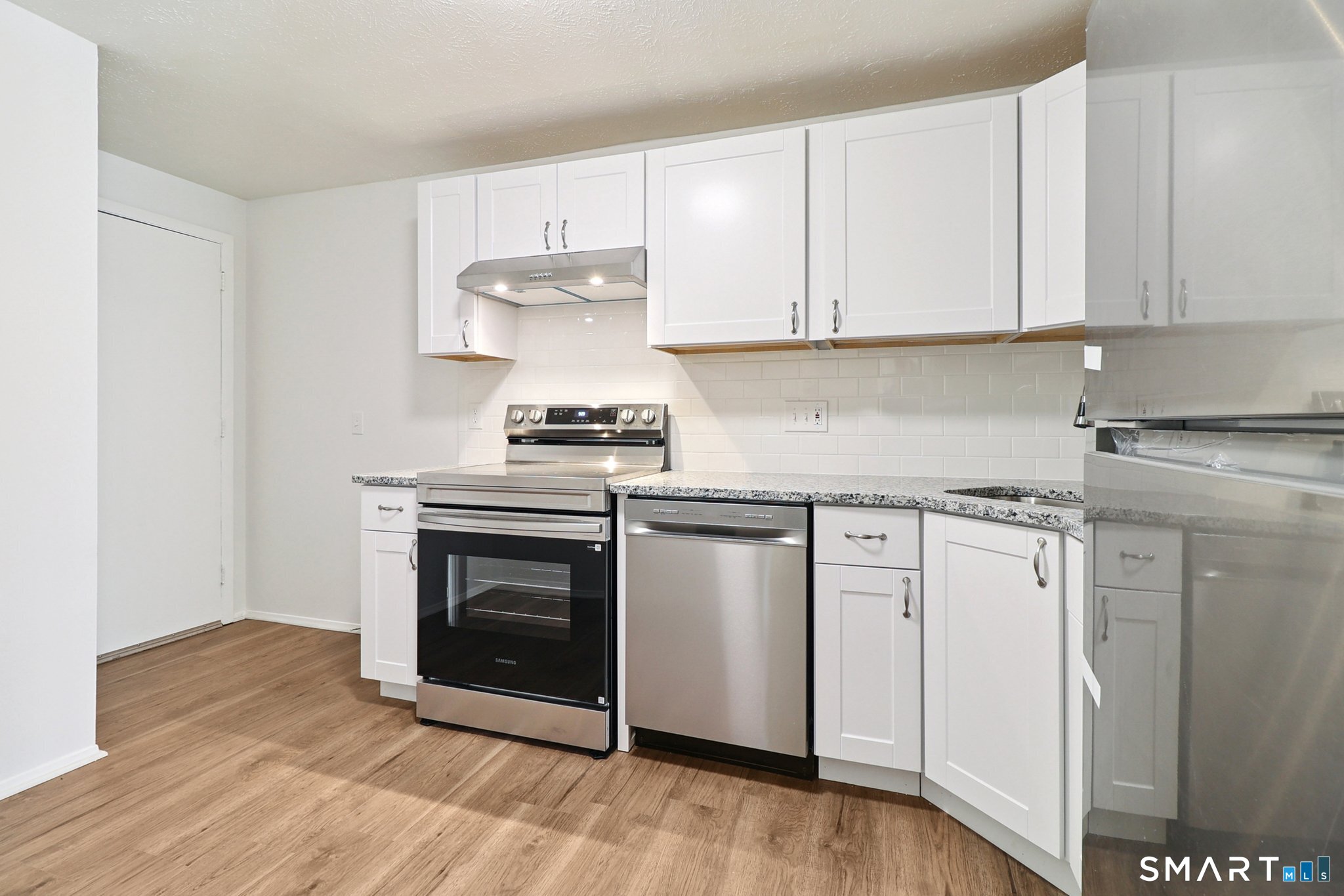 172 Towne House Road, Unit 172 Hamden, CT 06514 - Photo 12 of 20 a kitchen with stainless steel appliances granite countertop a stove a sink and white cabinets