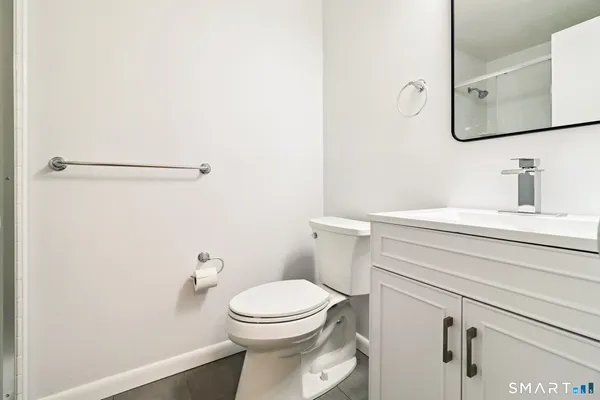 a bathroom with a toilet sink and mirror