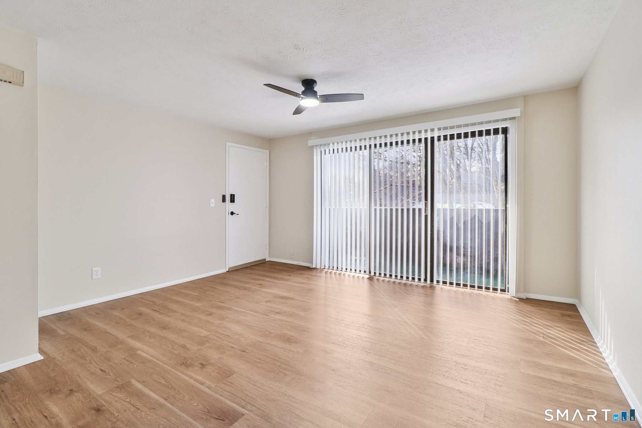 172 Towne House Road, Unit 172 Hamden, CT 06514 - Photo 7 of 20 an empty room with wooden floor fan and windows