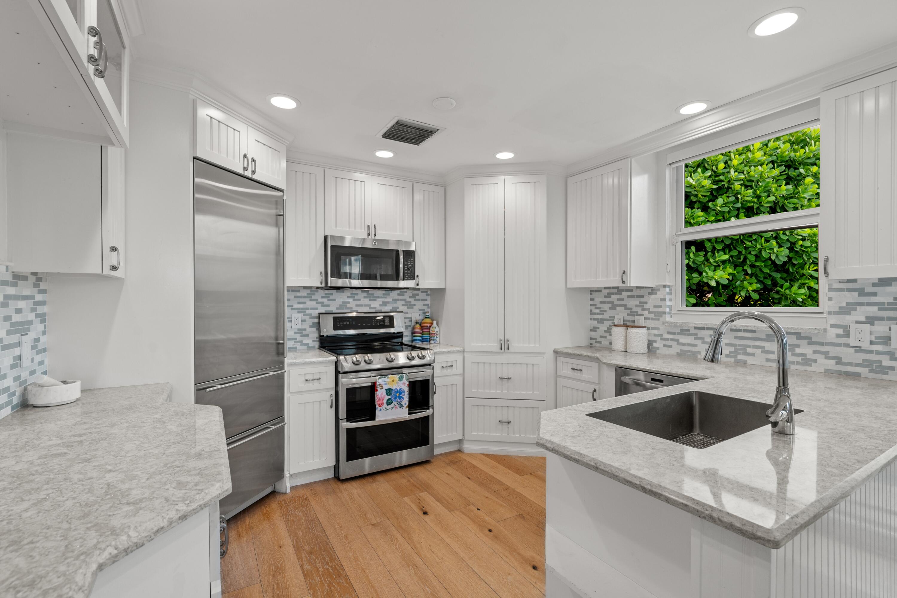 5111 North Ocean Boulevard, Unit A Ocean Ridge, FL 33435 - Photo 18 of 47 a kitchen with a sink white cabinets and stainless steel appliances