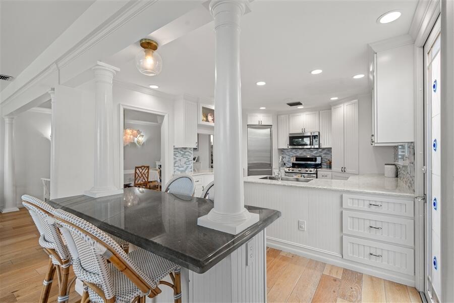 5111 North Ocean Boulevard, Unit A Ocean Ridge, FL 33435 - Photo 21 of 47 a kitchen with kitchen island granite countertop a table chairs sink and cabinets