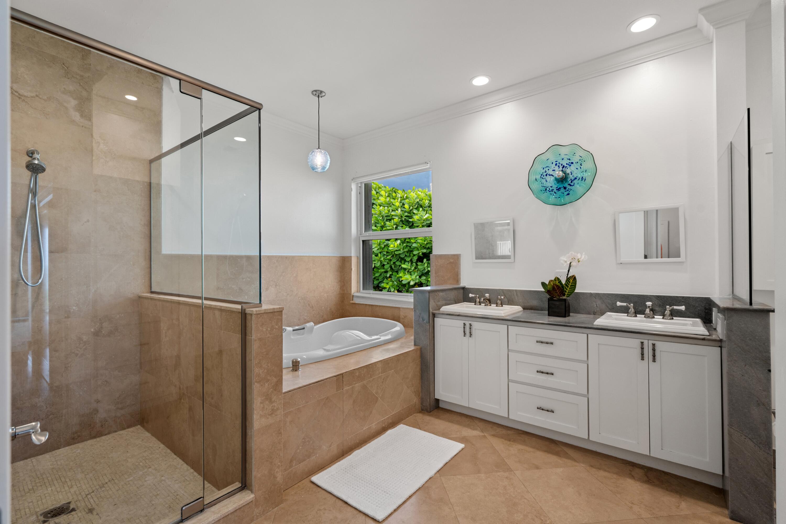 5111 North Ocean Boulevard, Unit A Ocean Ridge, FL 33435 - Photo 30 of 47 a bathroom with a double vanity sink a mirror a bathtub and a shower