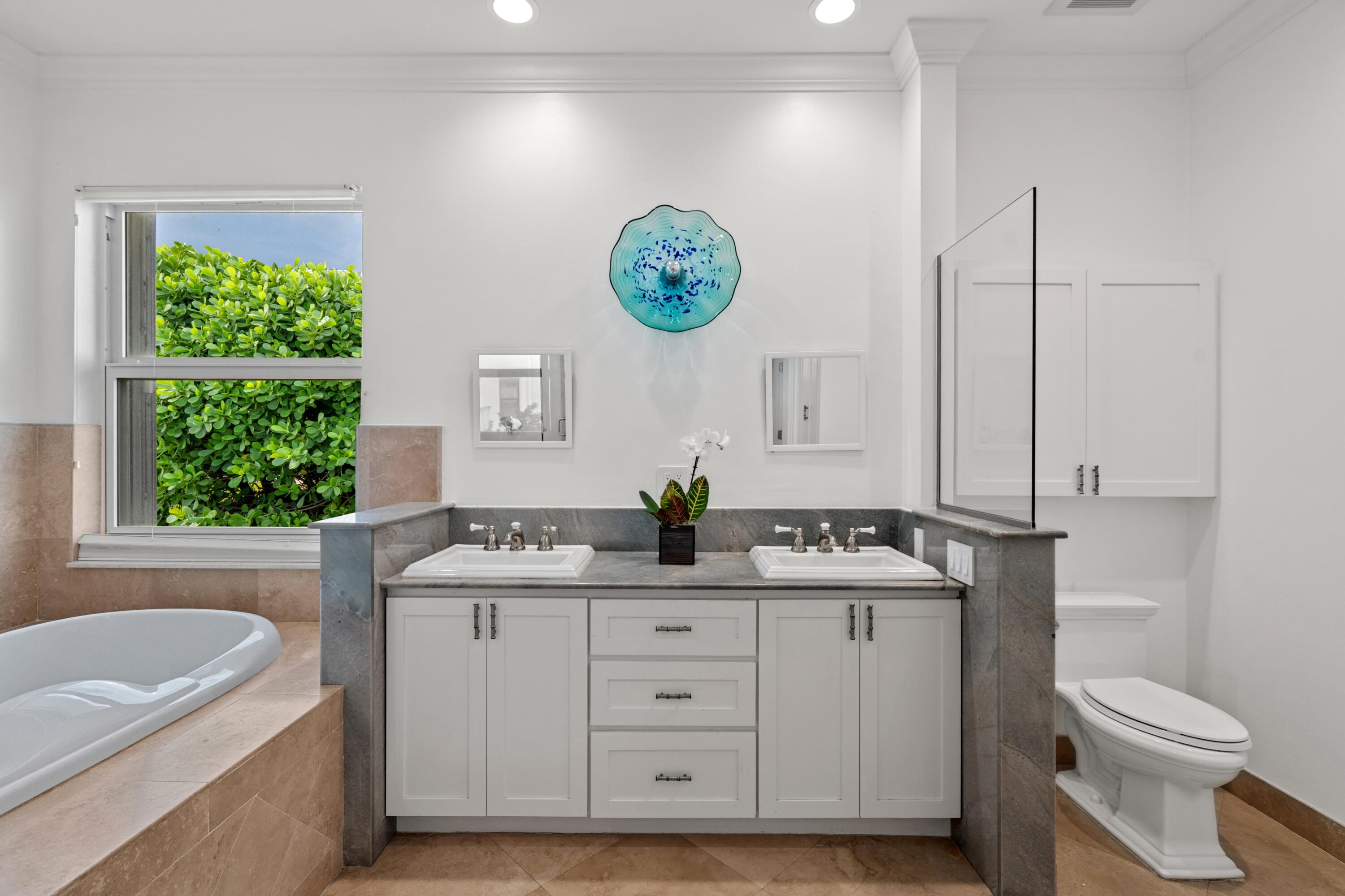 5111 North Ocean Boulevard, Unit A Ocean Ridge, FL 33435 - Photo 31 of 47 a bathroom with a granite countertop sink toilet and a bathtub