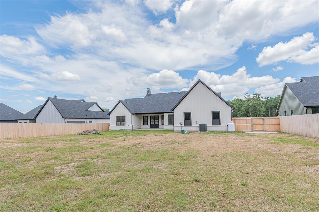 360 Dalton Road Canton, TX 75103 - Photo 27 of 33 Expansive rear yard featuring a newly constructed residence with white vertical siding and dark trim