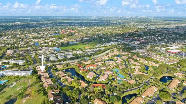 an aerial view of residential houses with outdoor space and trees
