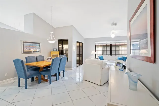 a living room with furniture a dining table and a large window