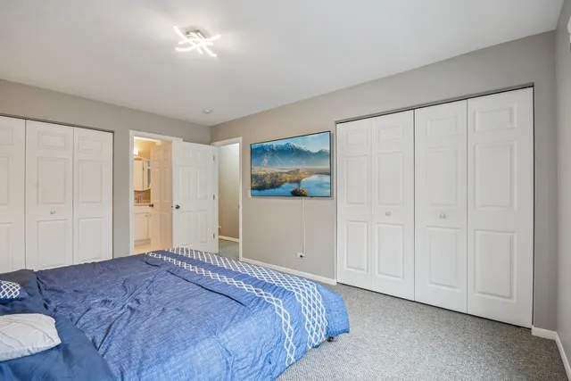 a bedroom with a bed and a painting on the wall