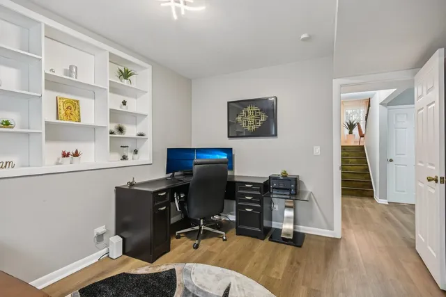 a view of a workspace with furniture and wooden floor
