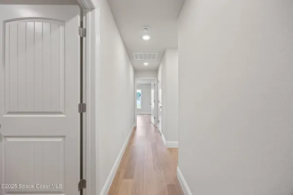 a view of an empty room with wooden floor