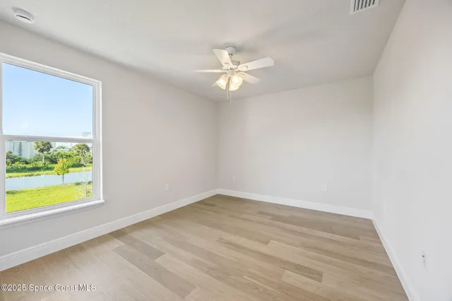 an empty room with window and a ceiling fan