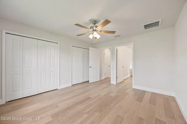 a spacious bathroom with a double vanity sink a toilet and a mirror