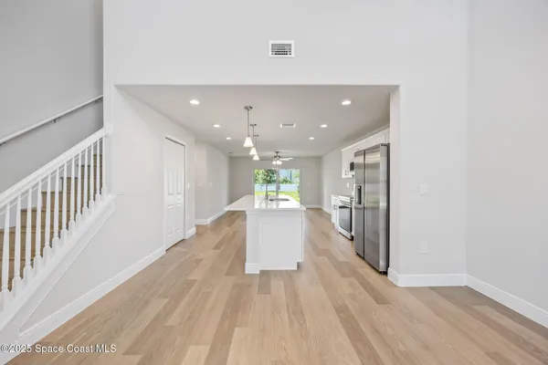 a view of a hallway with wooden floor and staircase