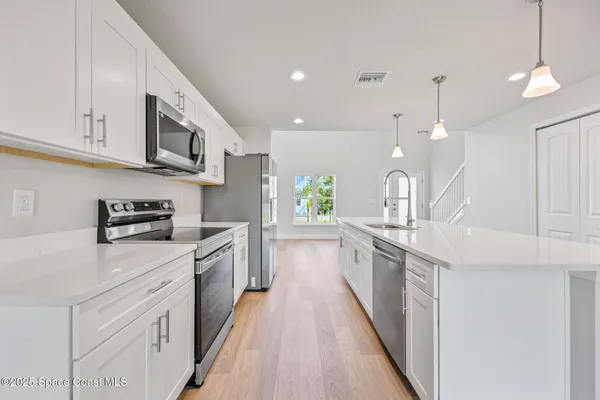 a large kitchen with stainless steel appliances lots of counter space sink and cabinets