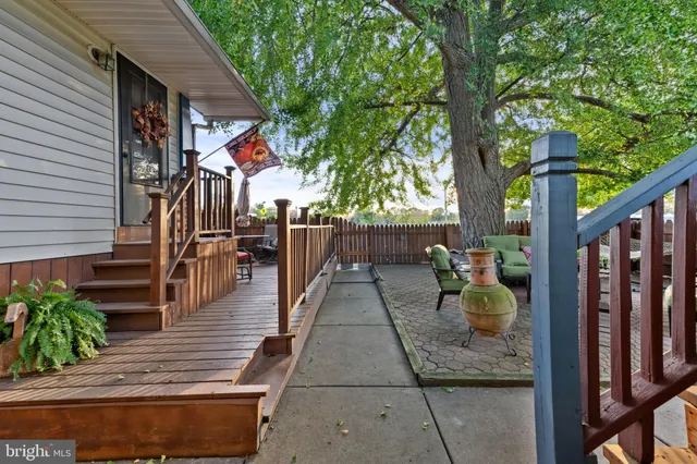 a view of a patio with couches table and chairs and potted plants