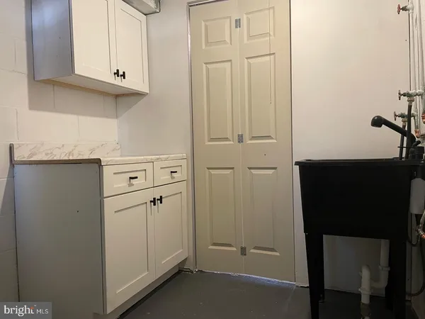 a view of cabinets and utility room with closet