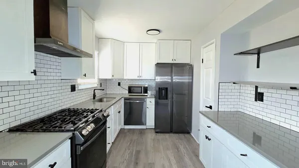 a kitchen with a stove a refrigerator and a sink